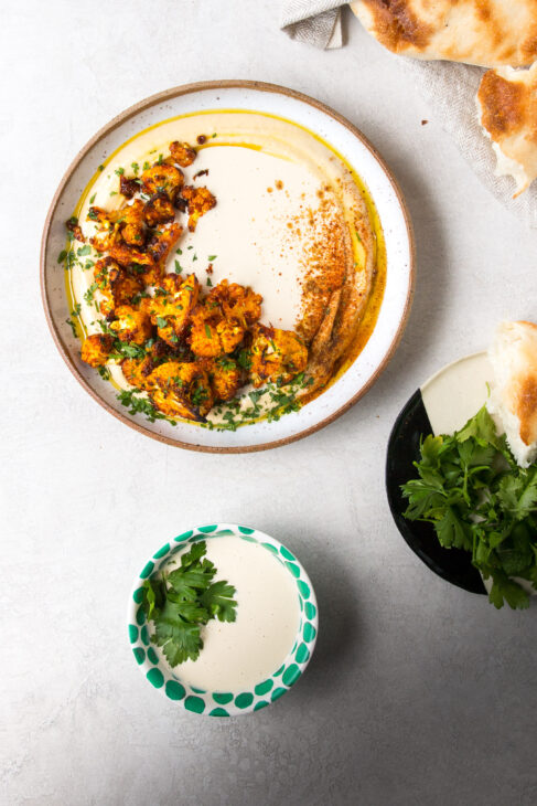 Roasted Harissa Cauliflower on Hummus with Tahini Sauce